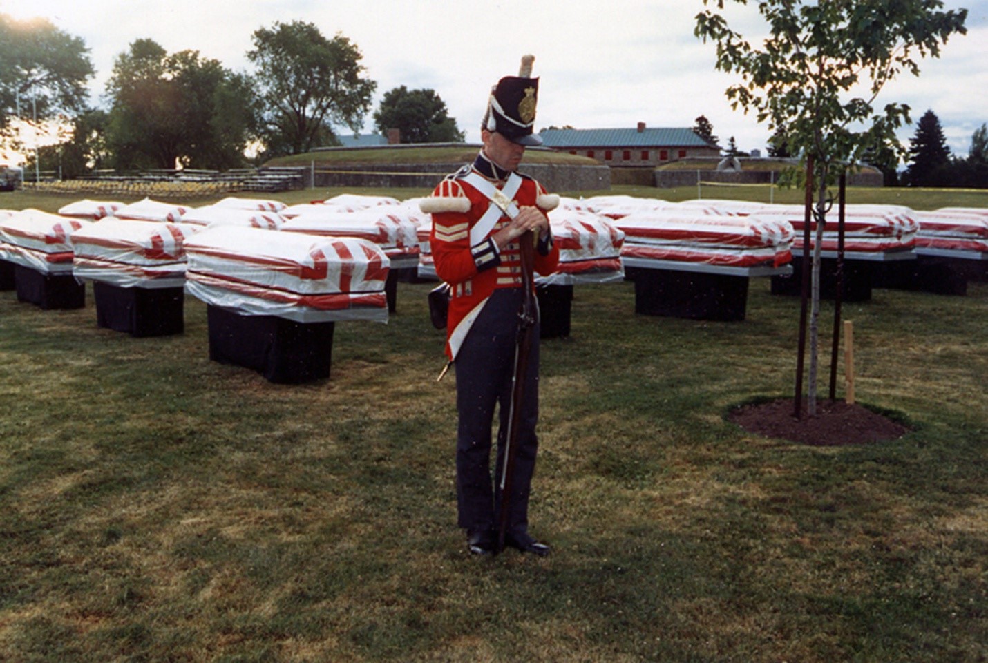 A British Soldier Reenactor stands in front of caskets.